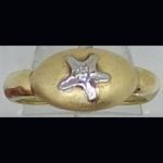 Sortija de oro amarillo con figura de estrella en oro blanco con brillante embutido