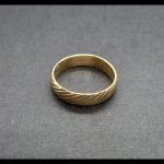 Anillo oro amarillo con dibujos en forma rayas oblicuas