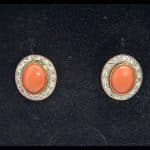 Pendientes oro amarillo con piedra central color coral y circonitas blancas; cierre "Omega"