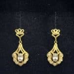 Pendientes semilargos oro amarillo con circonitas blancas; cierre forma "mariposa"