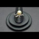Anillo oro blanco forma cruzada con perla blanca y 5 brillantes de 0,03qt; total 0,15 qts