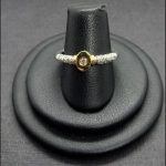 Anillo oro blanco con puntas de brillantes, en el centro tiene un brillantes de 0,06 qtes engastado en oro amarillo