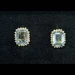 Pendientes oro amarillo con piedra celeste rodeada de circonitas, cierre tipo omega