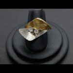 Anillo oro amarillo y blanco con dibujos de rayas y dos brillantes de 0,1qtes cada uno