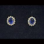 Pendientes oro amarillo de 18 kt con forma de roste con circonitas blancas y piedra azul en el centro, cierre tipo omega
