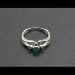 Anillo oro blanco de 18 kt con piedra cantral de color verde y dos brillantes de 0,01 qtes cada uno, nº 13
