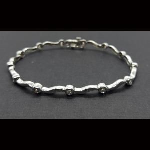 Pulsera oro blanco de 18 kt con 13 brillantes total 0,65qtes con eslabones forma de ondas 18,5 cm