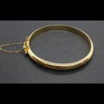 Pulsera oro amarillo tipo caña lisa con cadena de seguridad