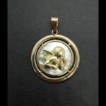 Colgante oro amarillo 18k con imagen de oro de un angel y en piedra de nacar