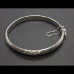 Pulsera oro blanco 18k tipo caña con dibujos y cadena de seguridad