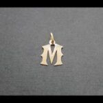Colgante oro amarillo 18k letra.M.