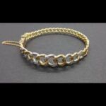 Pulsera oro amarillo y blanco de 18k rigida eslabón barbada con cadena de seguridad y puntas de brillantes