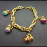 Pulsera oro amarillo 18k eslabones ovalados entrelazados con 4 colgantes forma de jarras