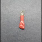 Colgante oro amarillo18k con forma de puño en color rojo
