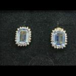 Pendientes oro amarillo 18k con piedra cuadrada de color celeste rodeada de circonitas cierre tipo omega