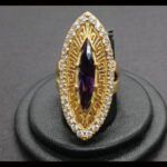 Anillo oro amarillo 18k tipo lanzadera con piedra central de color lila rodeada de circonitas nº 22