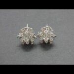 Pendientes oro blanco 18qt forma roseta con brill.central de 0,20 qt y 6 brill.de 0,05 qt;total 0,50 qt cada uno
