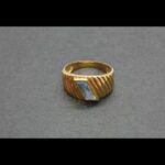 Anillo oro amarillo 18 qt nº 18 parte central formando rayón con piedra color celeste