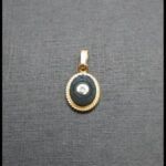 Colgante ovalado oro amarillo 18 qt con piedra negra y punta brillante engarzado sobre oro blanco
