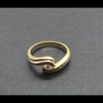 Anillo oro amarillo y blanco 18k con forma ondulada decorada con un brillante de 0,10qtes nº 14,5