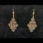 Pendientes oro amarillo 18k largos con circulos unidos con detalles en oro blanco en el centro, cierre tipo gancho cerrado
