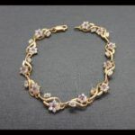 Pulsera oro amarillo 18k con eslabones con forma de flor con circonitas blancas y en el centro corinta 18cm
