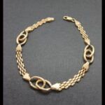 Pulsera oro amarillo 18 qt eslabon tipo cadena con un centro entrelazado (20 cm)