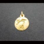 Medalla oro amarillo 18 qt diseño cigüeña con recien nacido,borde tallado a mano