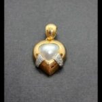 Colgante oro amarillo 18 qt forma corazón con perla central y pequeños brillantes incrustados en oro blanco en laterales