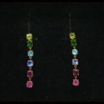 Pendientes largos oro amarillo 18 k con hilera de gemas de colores, cierre forma mariposa