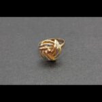 Anillo entrelazado en oro tricolor 18k nº 16,5 con pequeña gema rojiza en el centro