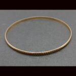Pulsera oro amarillo 18k tipo aro con rayas
